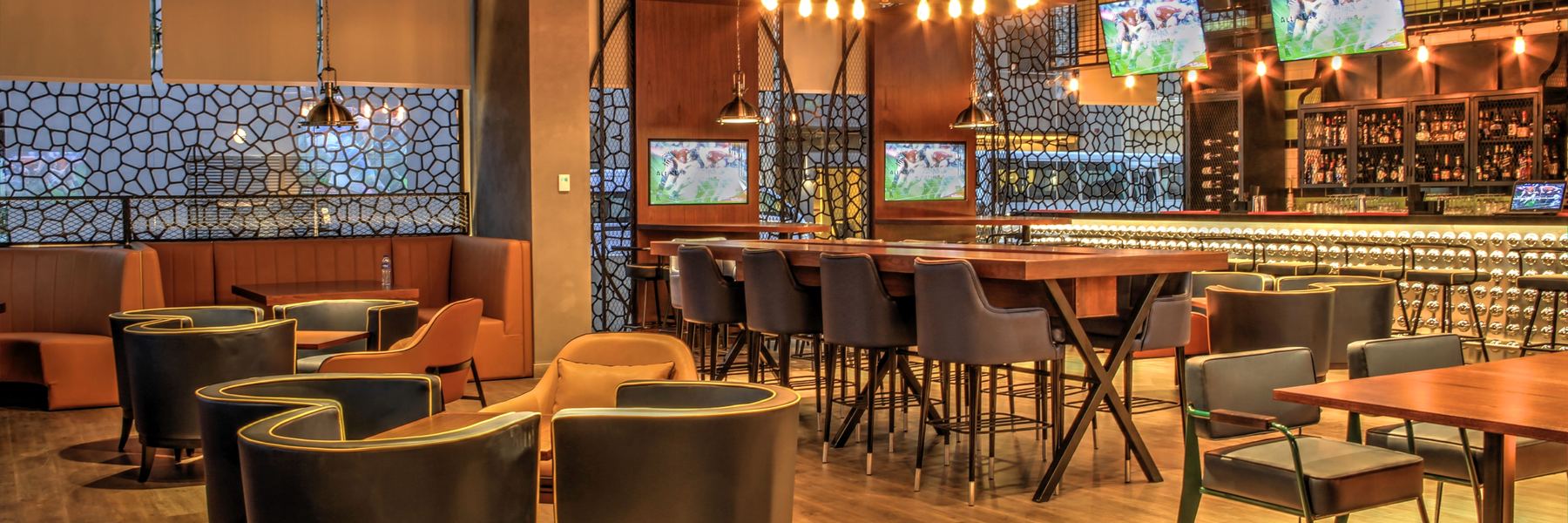 Sportcafe met schermen boven de bar en aan de wand